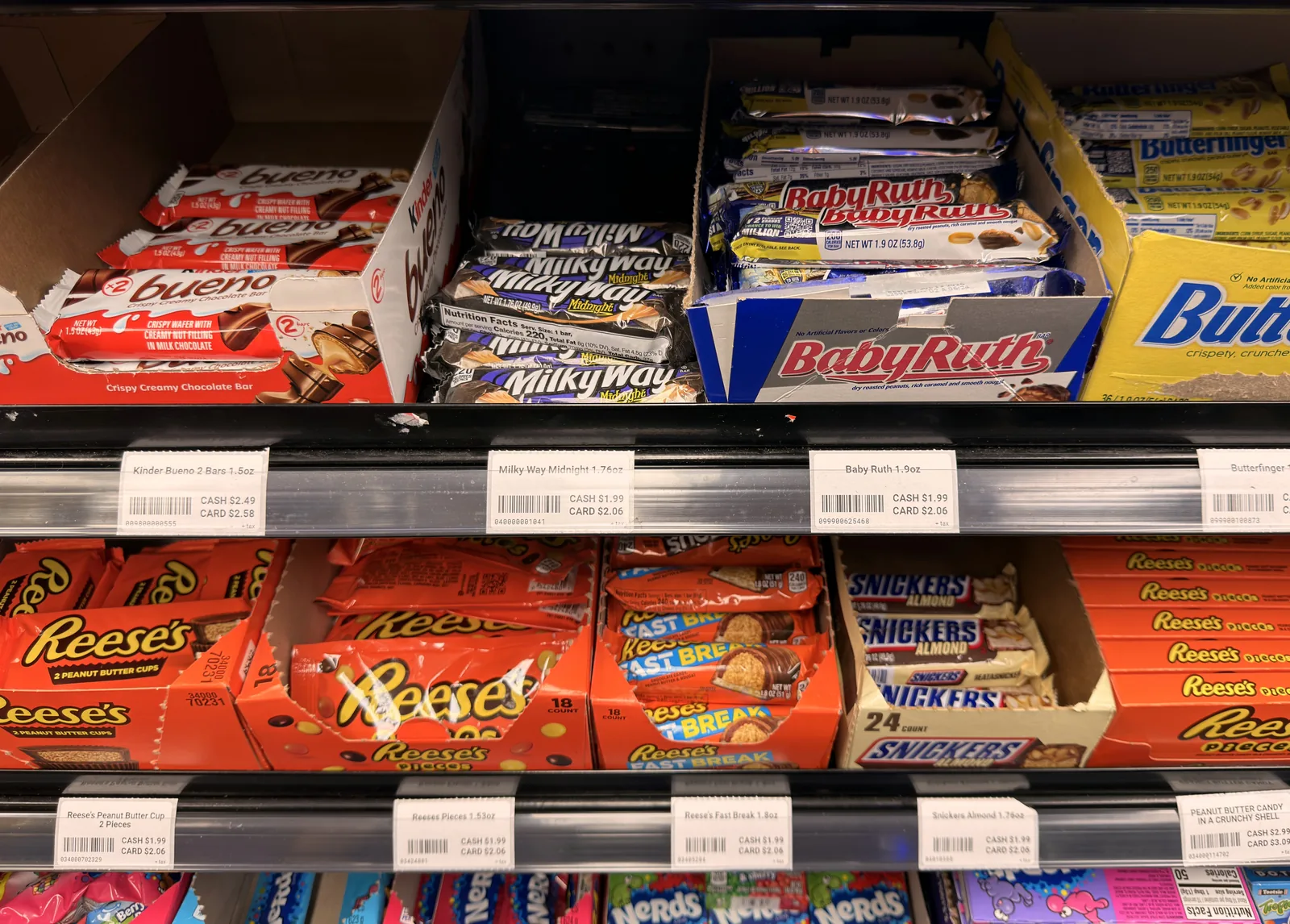 The same shelf with printed SleetPOS labels showing cash and card prices